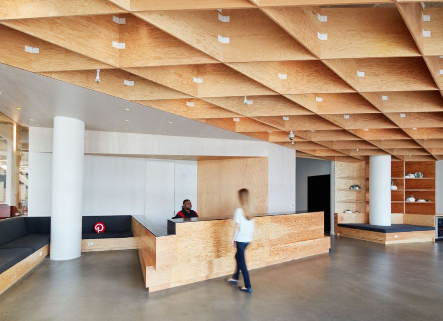 woman in lobby of Pinterest headquarters building with wooden ceilings