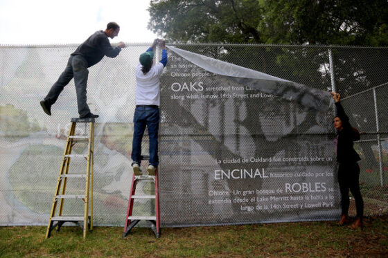 Men putting Sign up on fence