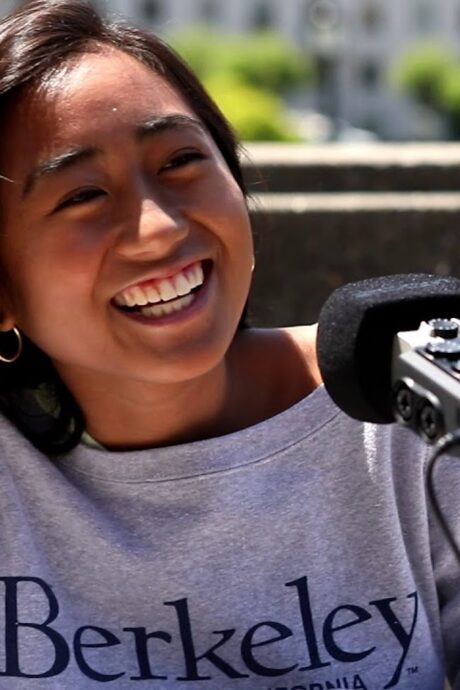 Student smiling speaking into a microphone