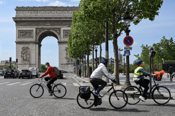 People biking in paris around the Arc de Triomphe