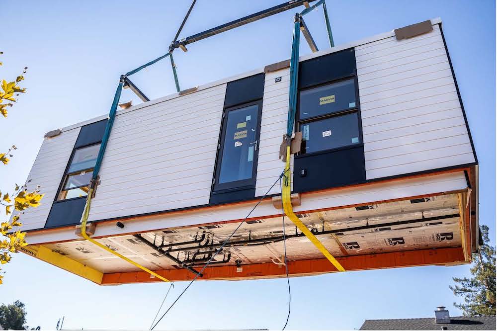 A small dwelling unit suspended from a crane