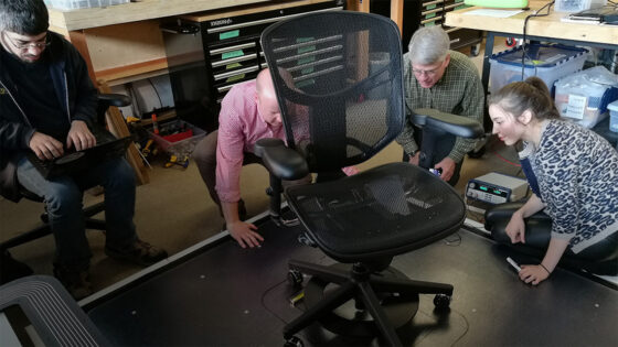 Students working on a wireless chair in a lab