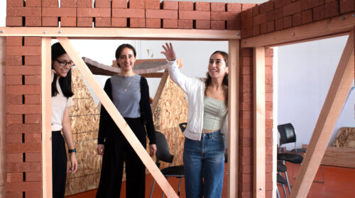 Three students with wood and brick framed wall