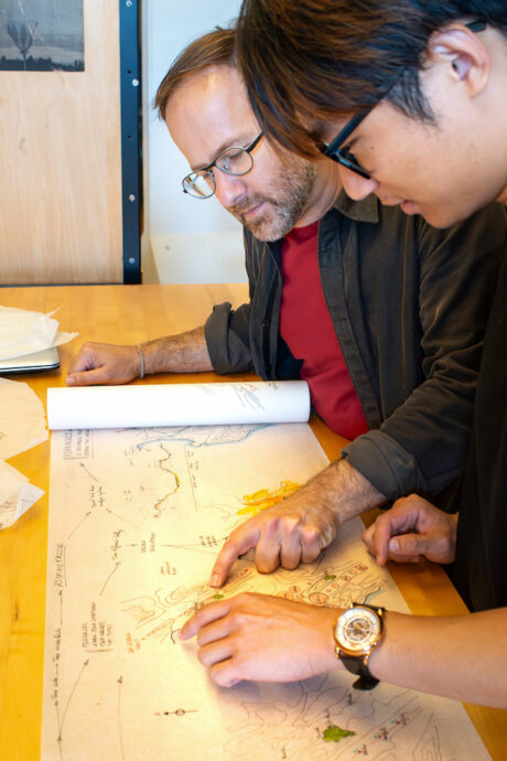 Teacher and student looking down at drawing