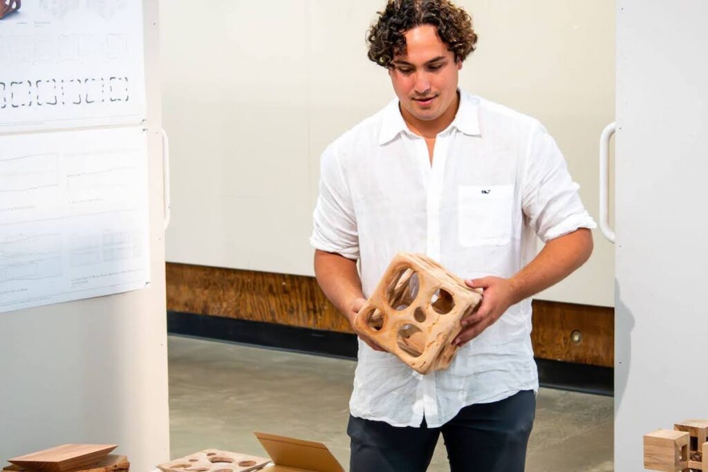 Student holding a wood model