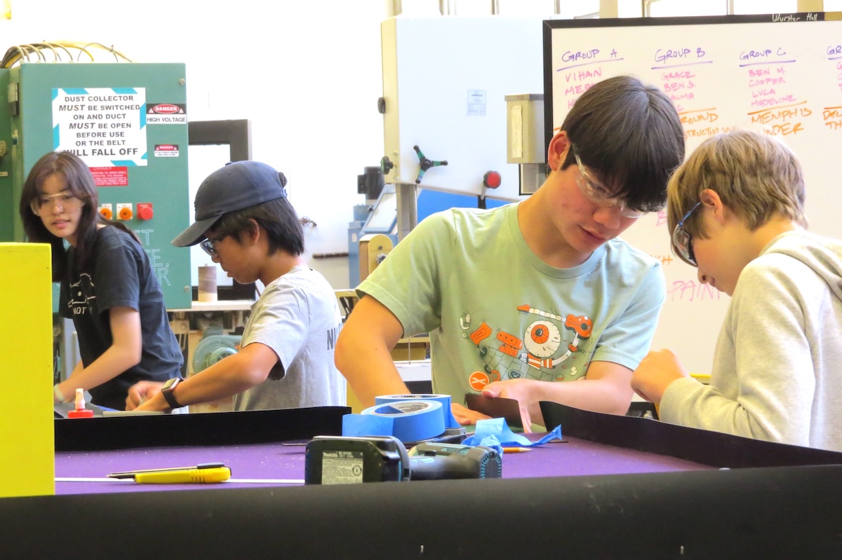 4 young students working in woodshop