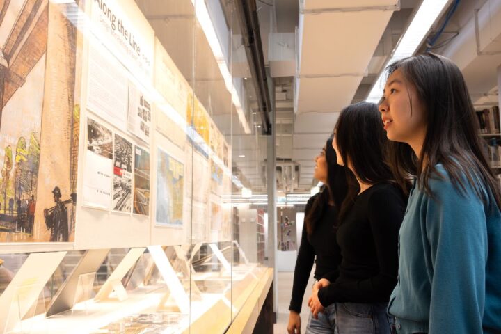 Students looking at an exhibit of architectural drawings