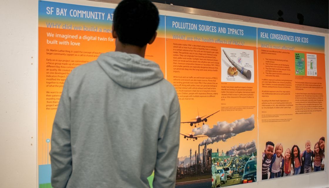 Student in front of poster boards about pollution